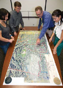 Four people reviewing Map Banner